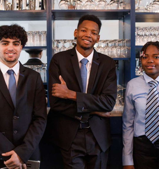 3 élèves devant le bar du restaurant